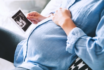 pregnant woman looking at ultrasound photo